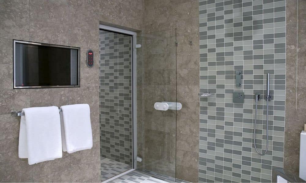 A luxurious bathroom with a built-in TV, music player, and DVD player